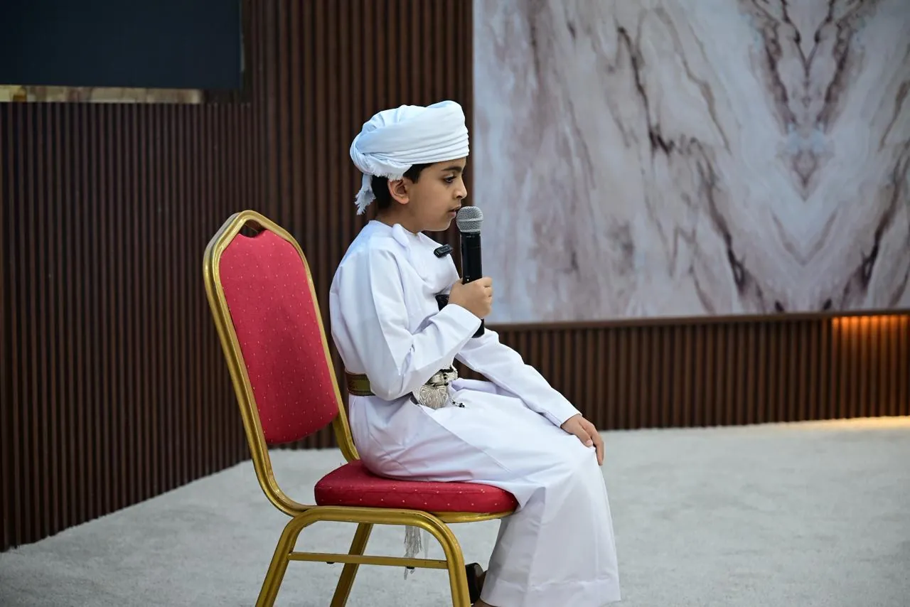 أحد الطلبة يقدّم تلاوة من القرآن الكريم في حفل التكريم